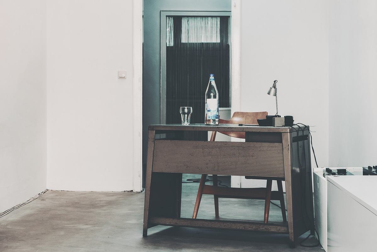 Wooden office desk and chair in an emptied white room